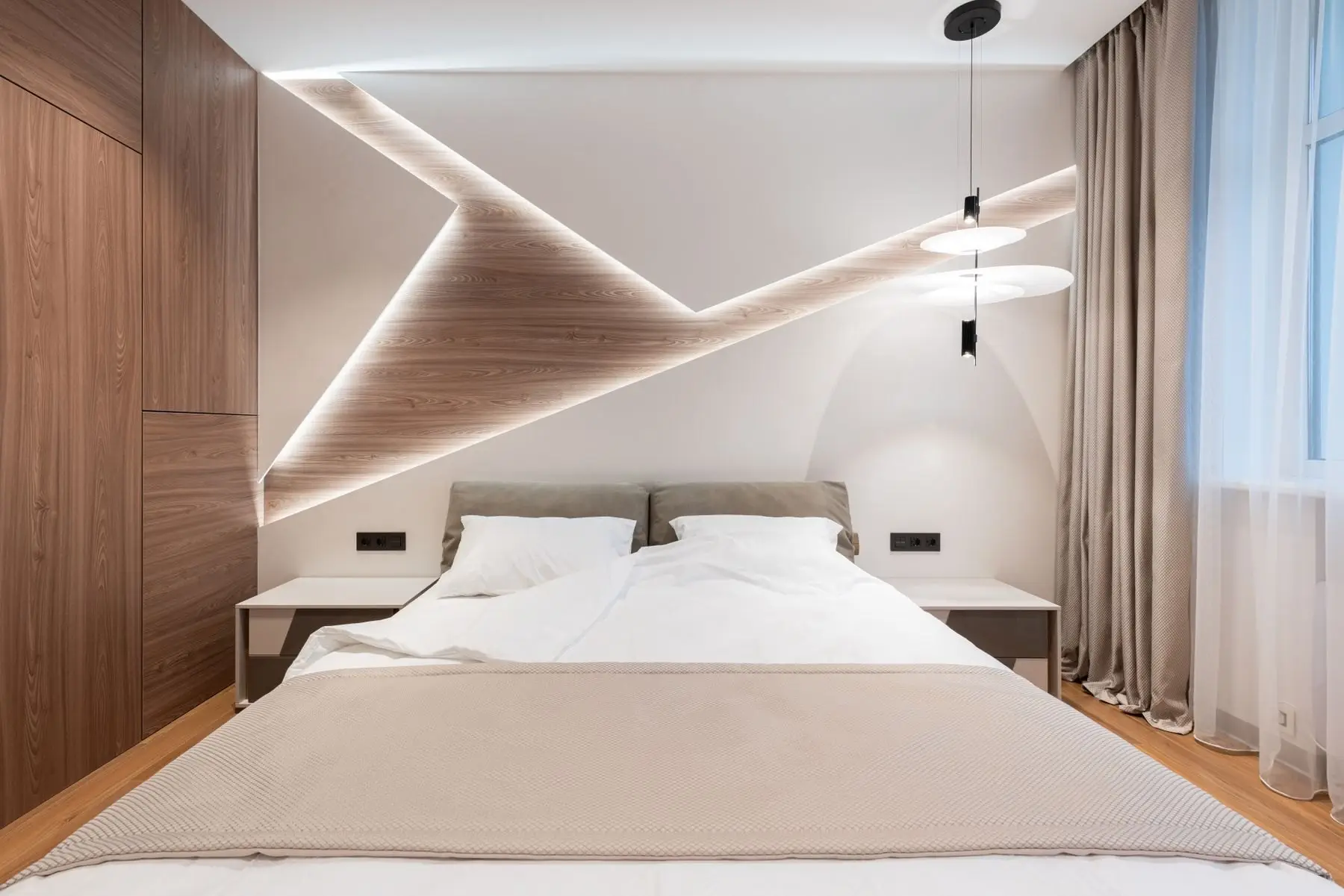 Habitación luminosa con cama doble de sábanas blancas, paredes blancas y madera clara